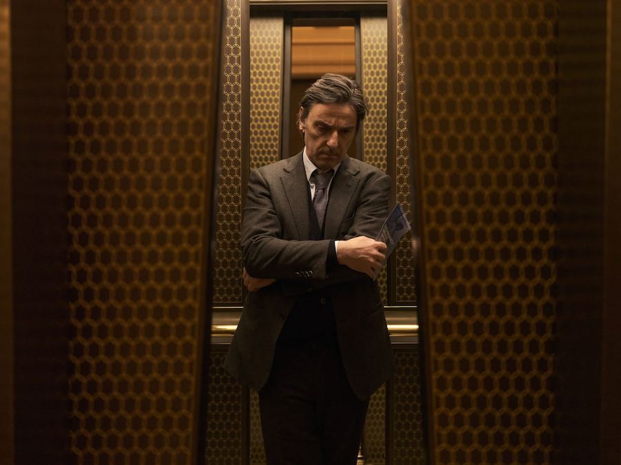 Yvan Attal en costume dans l'ascenseur dans Maestro(s) de Bruno Chiche.
