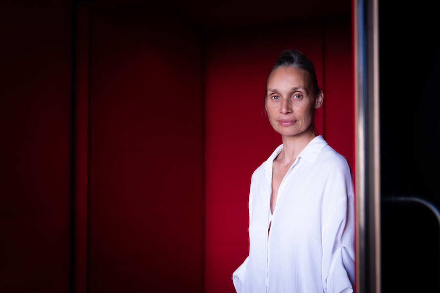 Julie Guibert sur fond rouge ex directrice du Ballet de l'Opéra de Lyon.