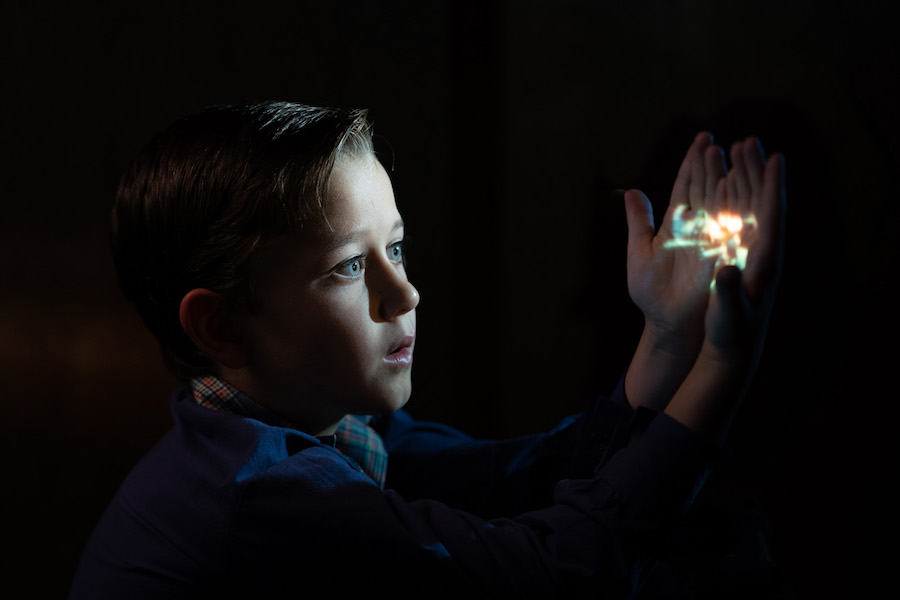 Le jeune Steven Spielberg regardant dans ses mains la lanterne magique du cinéma.