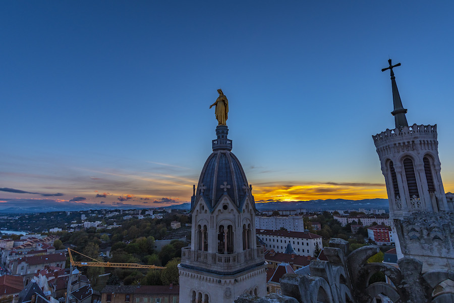 La statue dorée de Marie soleil couchant sur les toits de la basilique de Fourvière à Lyon.