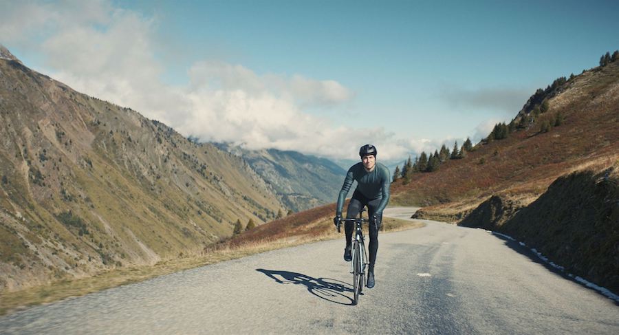 Bastien Bouillon sur son vélo casque et tenue de cycliste sur une route de montagne La Nuit du 12.