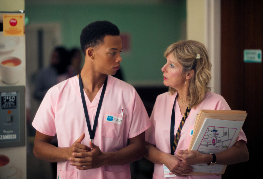 Melvin Boomer et Karin Vird en blouses roses à l'hôpital dans Sage-Homme.