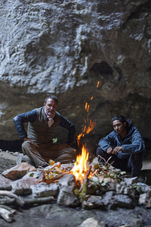 Jean Dujardin et Dylan Robert autour du feu dans une grotte de Sur les chemins noirs.