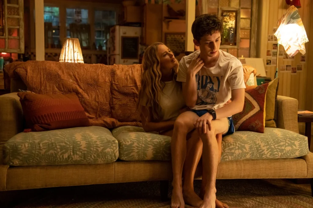 Andre Barth Feldman sur les genoux de Jennifer Lawrence assise sur un canapé lumière orangée.