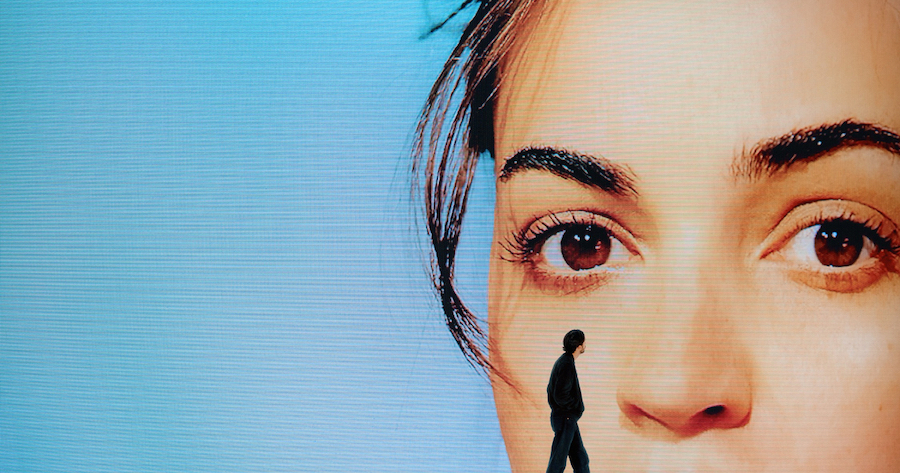 Lomepal silhouette devant affiche bleue visage de jeune femme.