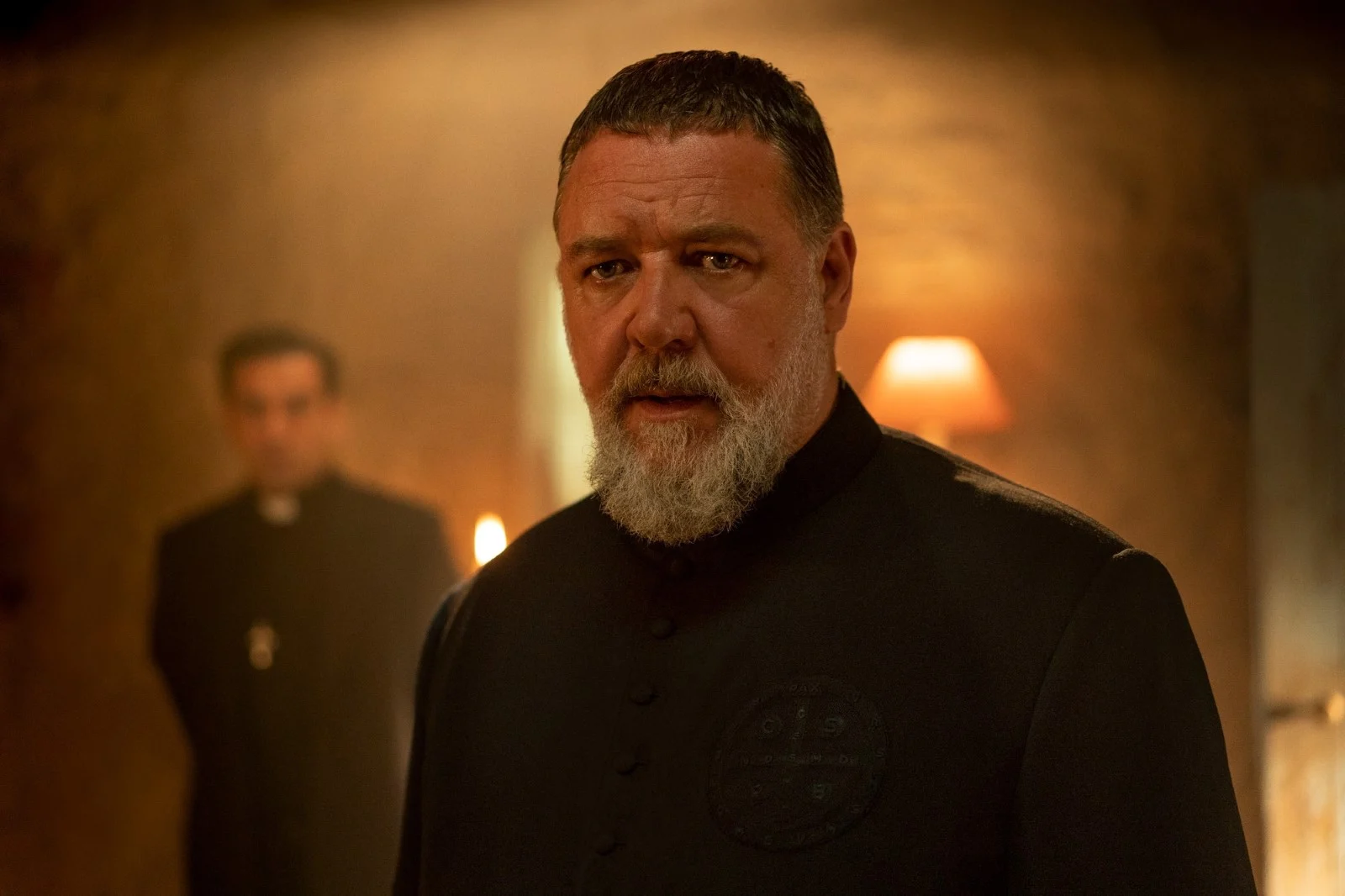 Russell Crowe prêtre exorciste fond orange