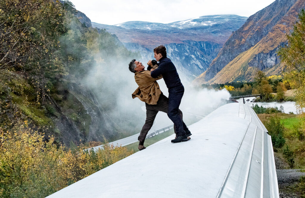 Tom Cruise se bat à maine nues sur le toit de l'Orient-Express au milieu des montagnes.
